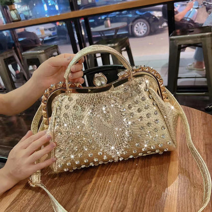 Gold embellished handbag on a wooden table with a blurred indoor background. Large genuine leather dumpling bag with diamond rhinestone clip and lock clasp. Soft handle, multiple compartments. Fashionable shoulder tote for women.