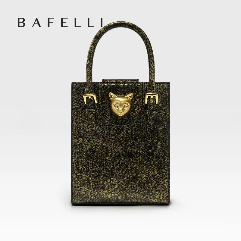 Gold handbag with a cat face emblem on a light gray background, featuring the brand 'Bafelli'. Unisex mini tote crossbody bag in split leather with flap pocket and lock closure. Hard box shape and polyester lining. Casual versatile style.