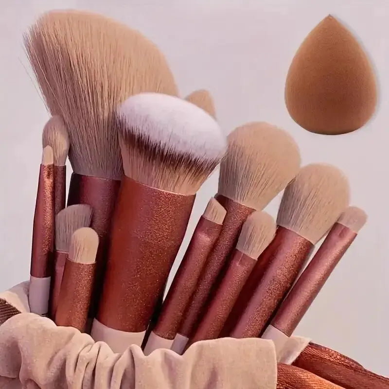 Set of makeup brushes with brown handles and a brown sponge on a light background. Soft fluffy makeup brush set with wool fiber bristles and plastic handles. Complete set for powder, foundation, eyeshadow, and beauty blending.