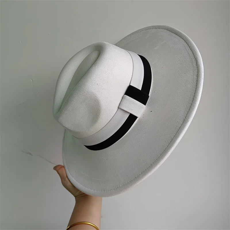 White hat with a black band held against a gray background