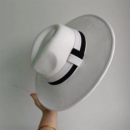 White hat with a black band held against a gray background
