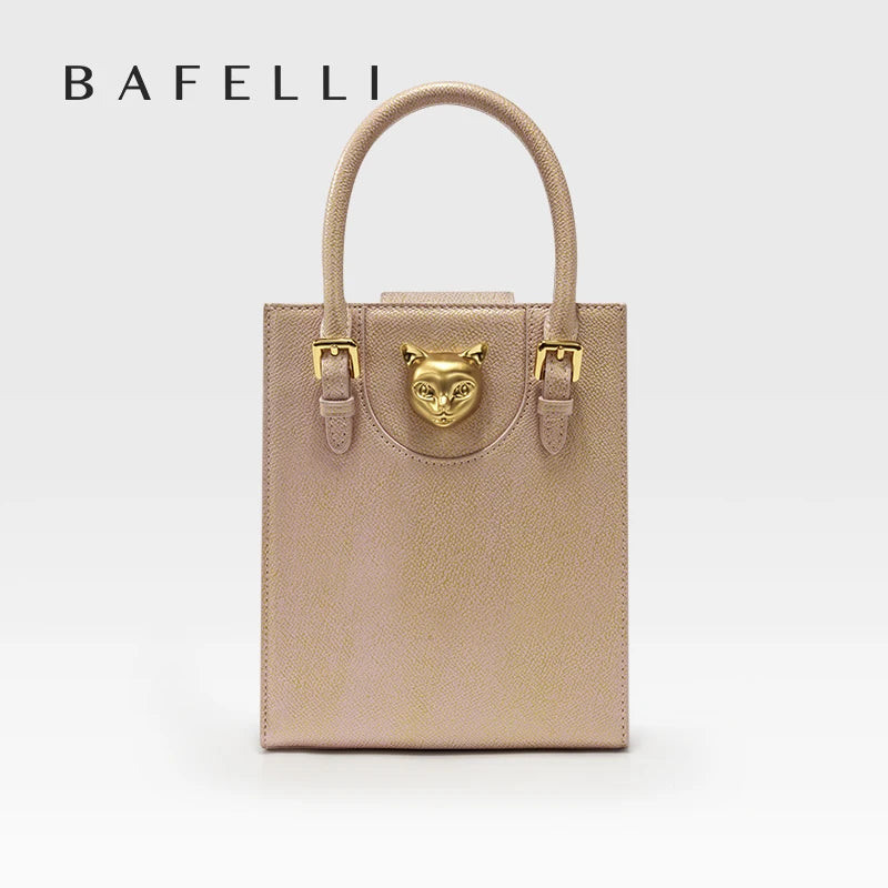 Beige handbag with gold accents featuring a cat face emblem on a white background, branded 'Bafelli'. Unisex mini tote crossbody bag in split leather with flap pocket and lock closure. Hard box shape and polyester lining. Casual versatile style.