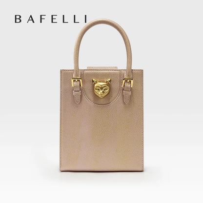 Beige handbag with gold accents featuring a cat face emblem on a white background, branded 'Bafelli'. Unisex mini tote crossbody bag in split leather with flap pocket and lock closure. Hard box shape and polyester lining. Casual versatile style.