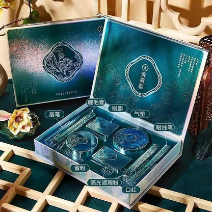 Makeup set with blue packaging on a decorative surface. Christmas makeup gift box with BB cream, lipstick, eyeshadow, eyebrow pencil, and brushes. Holiday beauty set for women & girls.