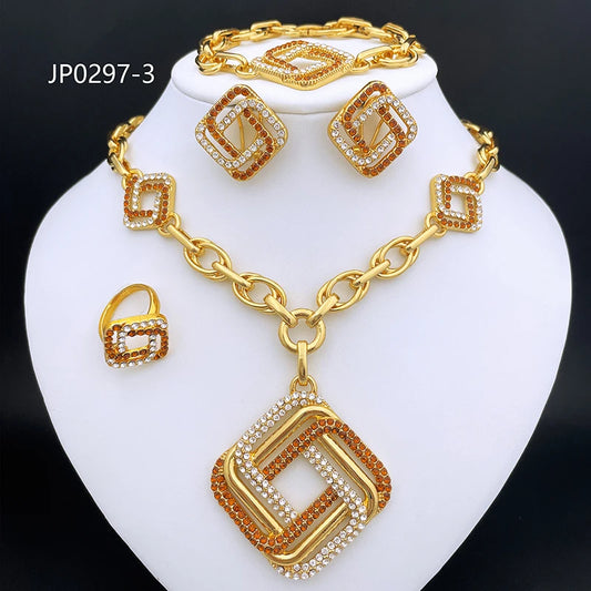 Gold-tone jewelry set on a white display bust, including a necklace with a large geometric pendant, matching earrings, and a ring, all decorated with clear rhinestones and orange-brown accents. The set is photographed against a black background.