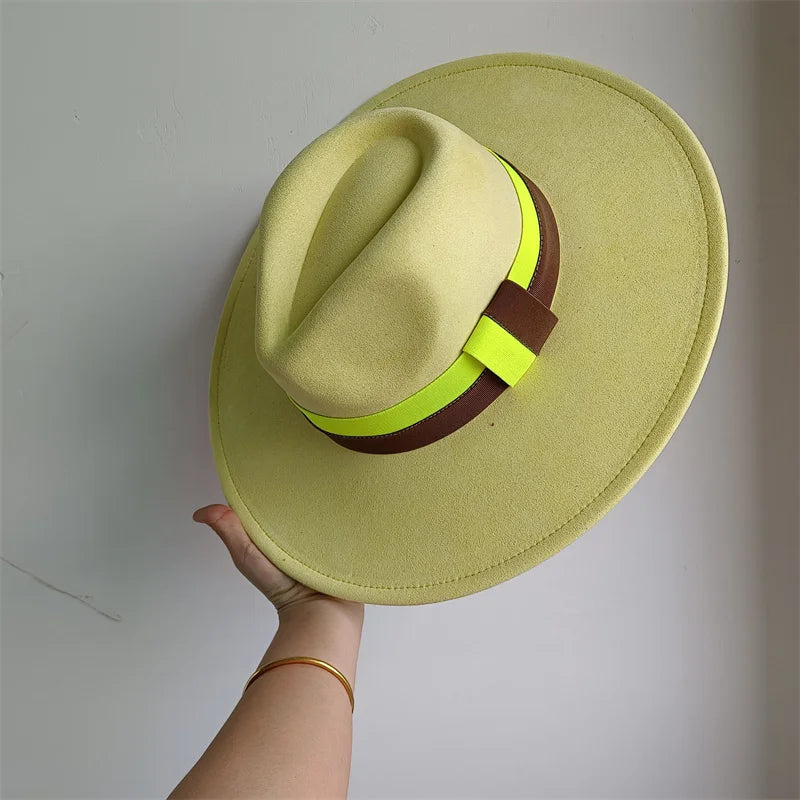 Light green fedora hat with a brown and yellow band held against a plain background