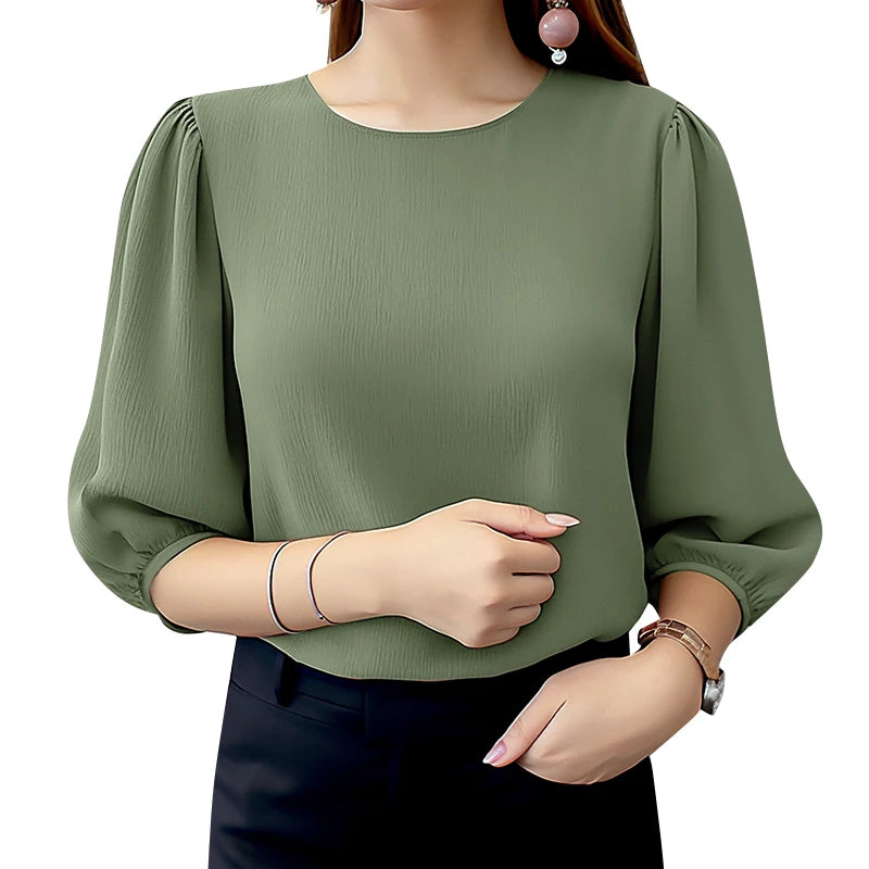 Green blouse with long sleeves worn by a person on a white background
