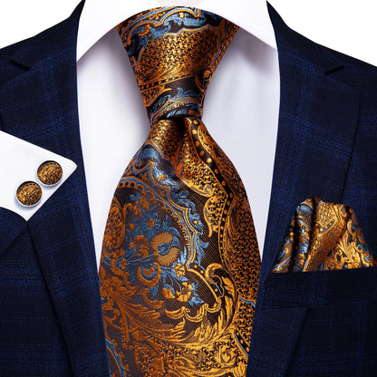 Navy suit with gold and blue paisley tie, pocket square, and cufflinks on a white background. Men’s luxury paisley silk tie and pocket square set, 8.5cm wide, for business or wedding. Red formal necktie, ftf fashion UK.