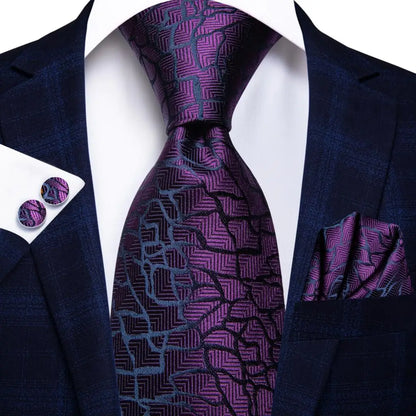 Navy suit with purple patterned tie, pocket square, and cufflinks on a white background. Men’s luxury paisley silk tie and pocket square set, 8.5cm wide, for business or wedding. Red formal necktie, ftf fashion UK.