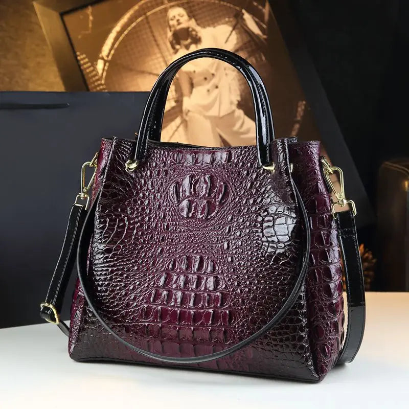 Purple textured handbag with gold accents on a white surface. Vintage genuine leather bucket tote bag with crocodile print. Soft medium-hardness leather, zipper closure, interior pockets. Stylish crossbody bag UK.