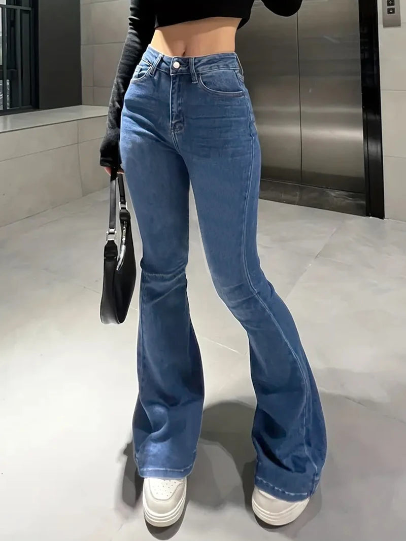 Person wearing blue flared jeans and white sneakers in an indoor setting. Women’s slim trumpet jeans mid waist in stretchy soft denim. Casual bell bottoms style with enzyme wash, perfect for UK fashion.