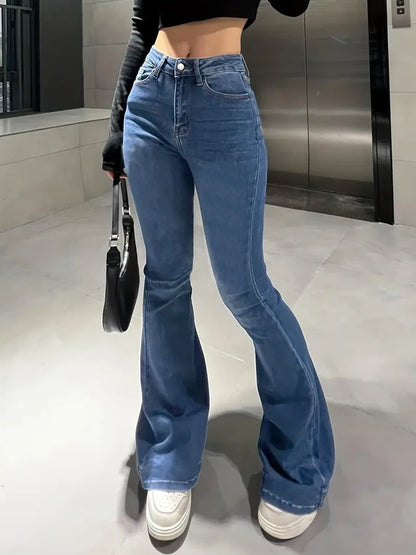 Person wearing blue flared jeans and white sneakers in an indoor setting. Women’s slim trumpet jeans mid waist in stretchy soft denim. Casual bell bottoms style with enzyme wash, perfect for UK fashion.