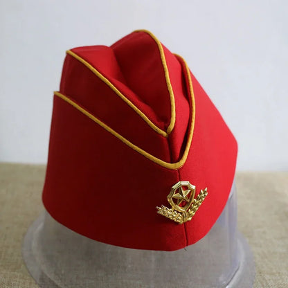 Red fez hat with gold trim and emblem on a clear stand against a light background