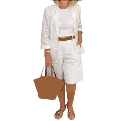 Image of a woman wearing a white Linen Look Blazer and Bermuda Shorts Co-ord Set with a brown belt and straw bag. Ideal smart casual summer outfit.