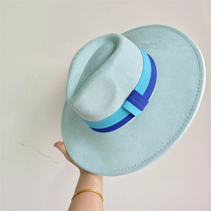 Light blue fedora hat with a blue band held against a light background