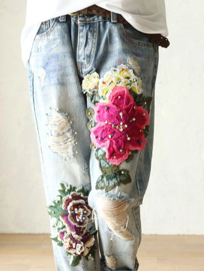 Denim pants with floral embroidery on a plain background. Floral embroidered harem jeans for women. Loose, high waist, elegant denim trousers. Vintage Y2K style. UK online store.