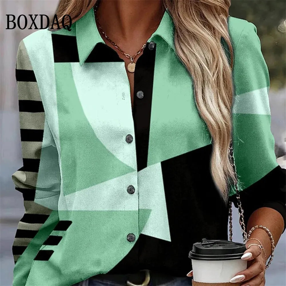 A woman wearing a long-sleeve button-up shirt with a bold geometric color-block pattern in mint green, black, and white. The shirt features a collar, dark buttons, and striped detailing on the sleeves.