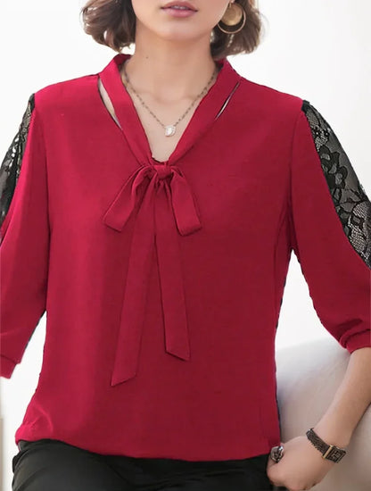 Red blouse with black lace sleeves worn by a person on a white background