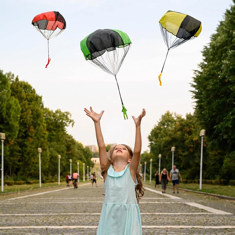Child playing with colorful paratroopers in a park. Colorful outdoor parachute toy for kids, tangle-free design. Durable plastic, unisex gift idea for boys and girls. UK delivery ftf fashion.
