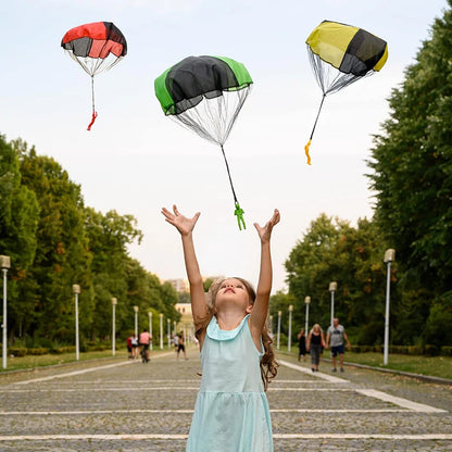 Child playing with colorful paratroopers in a park. Colorful outdoor parachute toy for kids, tangle-free design. Durable plastic, unisex gift idea for boys and girls. UK delivery ftf fashion.