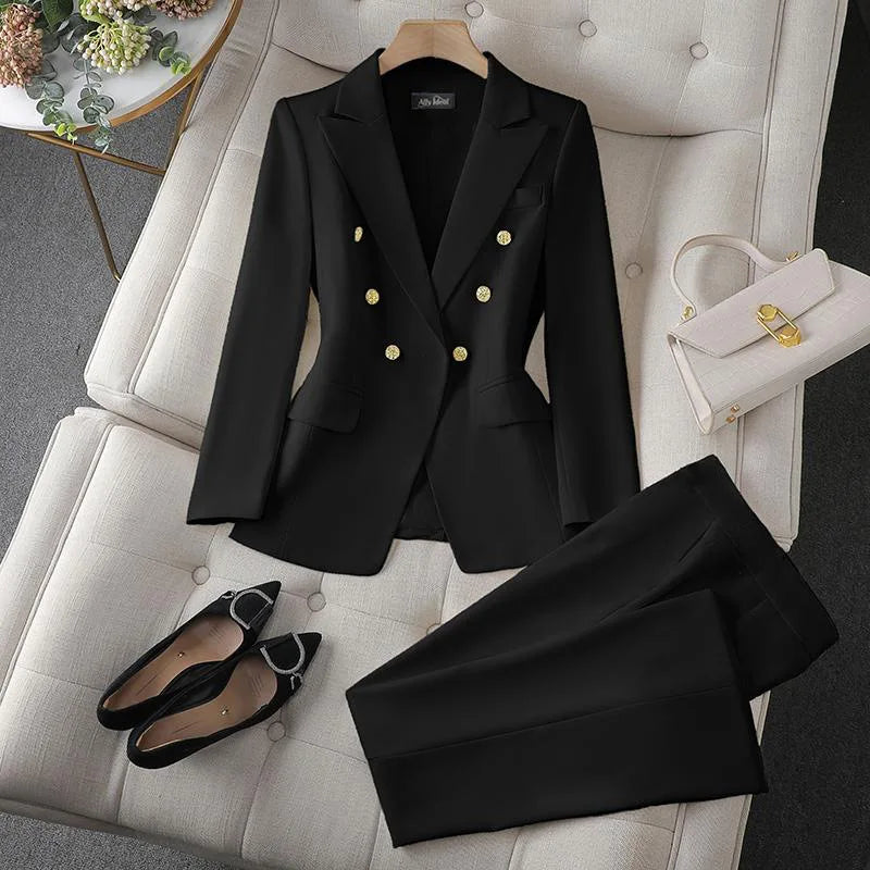 Black suit with gold buttons on a white chair, accompanied by black shoes and a white handbag.