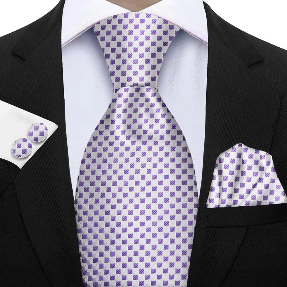 Man wearing a black suit with a purple and white checkered tie, pocket square, and cufflinks. Elegant men’s 3-piece tie set: striped necktie, floral pocket square, matching cufflinks. Fashionable polyester accessories for formal occasions.