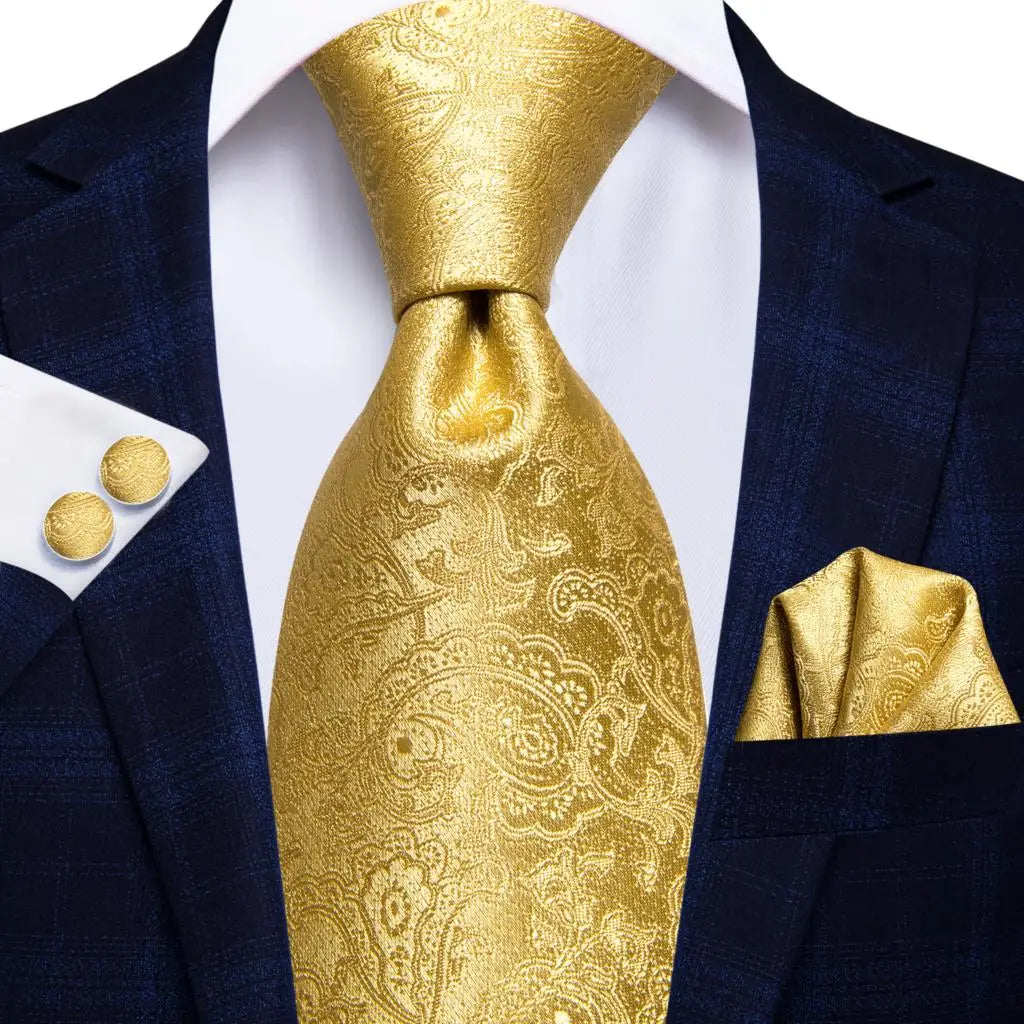 Gold paisley tie with matching pocket square and cufflinks on a navy suit. Men’s luxury paisley silk tie and pocket square set, 8.5cm wide, for business or wedding. Red formal necktie, ftf fashion UK.