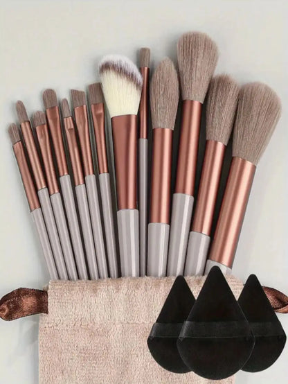 Set of makeup brushes with rose gold and gray handles in a holder on a light background. Soft fluffy makeup brush set with wool fiber bristles and plastic handles. Complete set for powder, foundation, eyeshadow, and beauty blending.