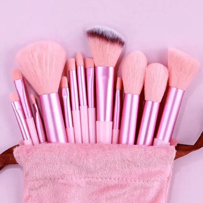Set of pink makeup brushes in a pink pouch on a light purple background. Soft fluffy makeup brush set with wool fiber bristles and plastic handles. Complete set for powder, foundation, eyeshadow, and beauty blending.