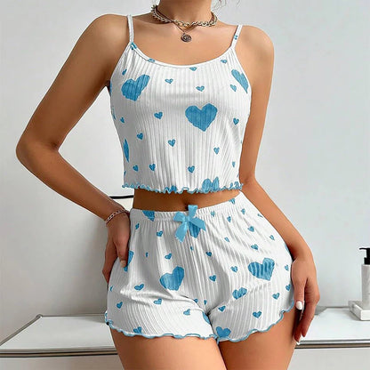 Woman wearing a white top and shorts set with blue heart patterns on a light background. Soft women’s pajama set, 2 pieces white tank top and shorts, breathable fabric with love print, comfortable casual sleepwear, UK FTF Market.