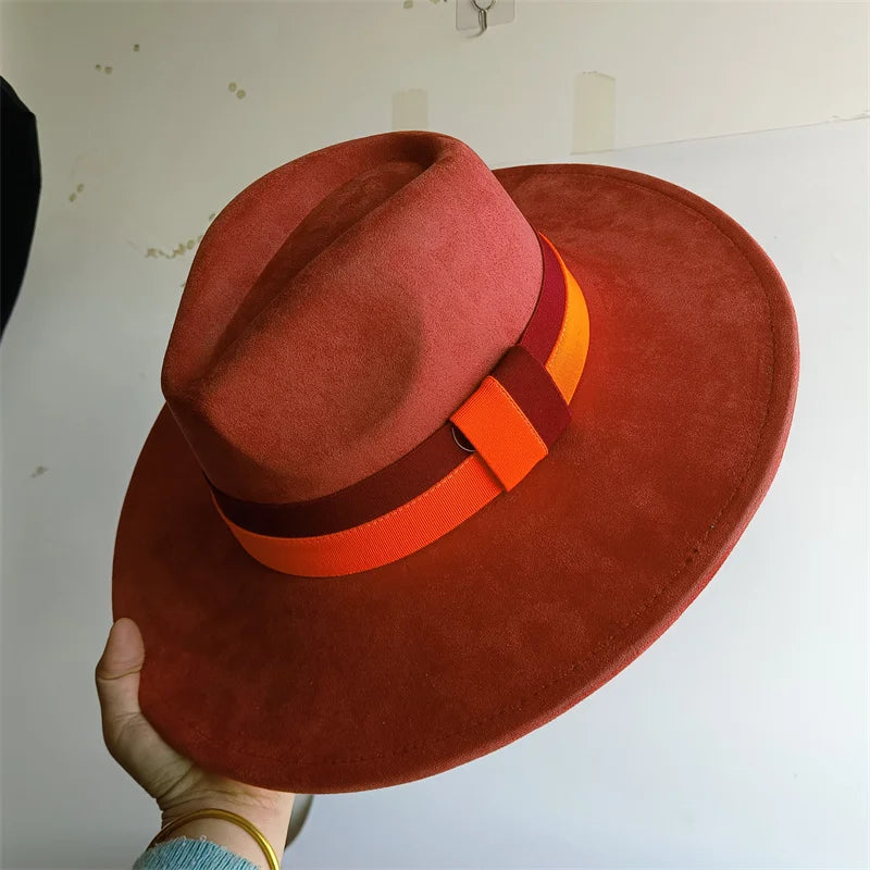 Red hat with an orange band held by a hand against a plain background