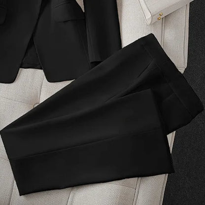 Black pants on a light gray surface with a blurred background