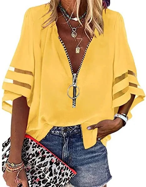 Person wearing a yellow zip-up top with striped sleeves, holding a leopard print clutch.