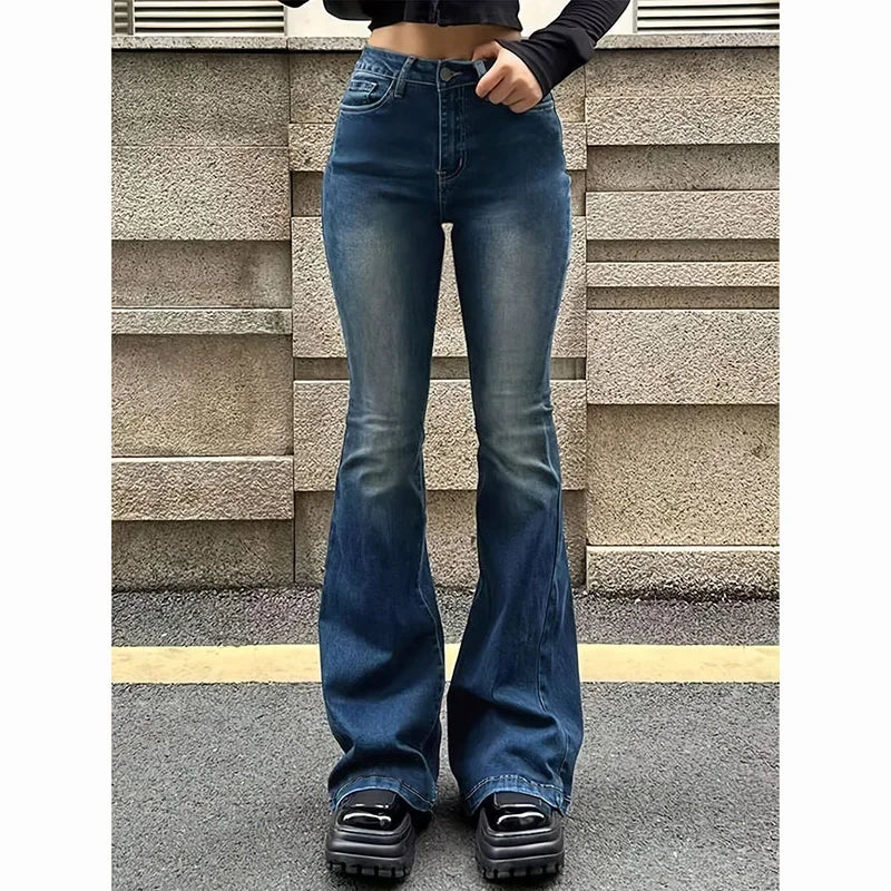 Person wearing blue flared jeans standing against a textured wall. Women’s high waist flared jeans, stretchy bootcut denim trousers. Thin fabric, solid color, bell bottoms style for casual chic UK fashion.
