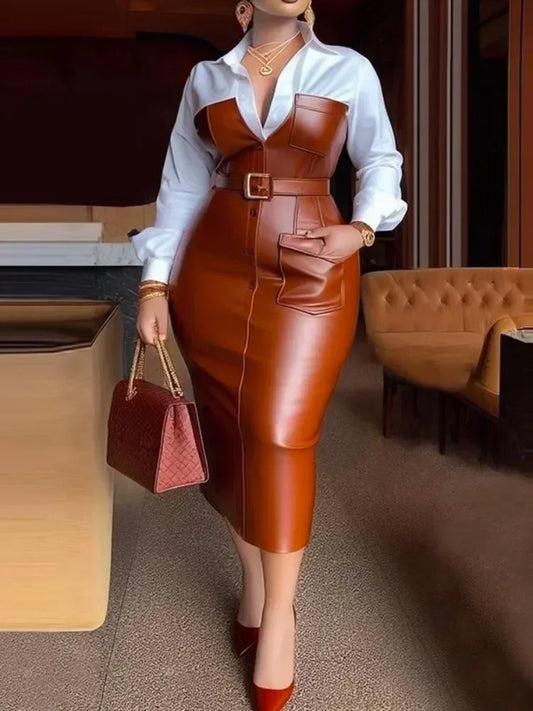 Person wearing a brown leather dress with a white shirt in an indoor setting.