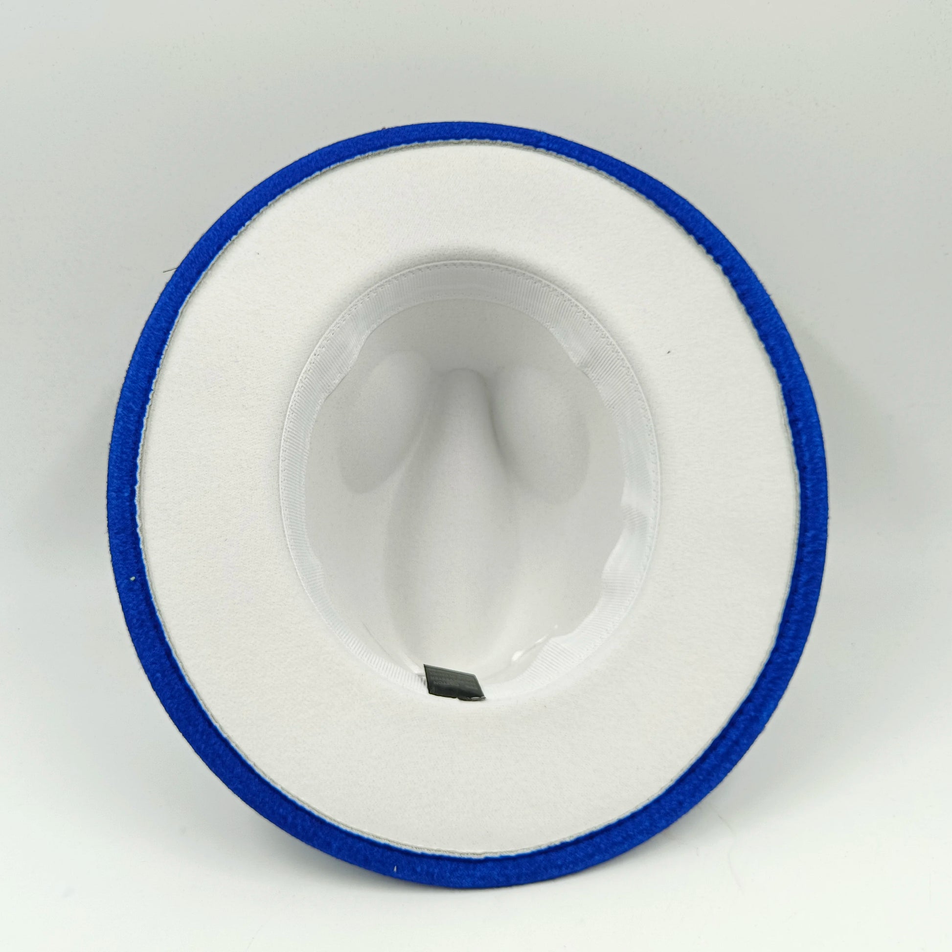 White ceramic spoon with blue rim on a gray background. Unisex double fedora hat, dual color gradient tie-dye, casual jazz style, cotton-polyester mix, suitable for outdoor autumn and spring.