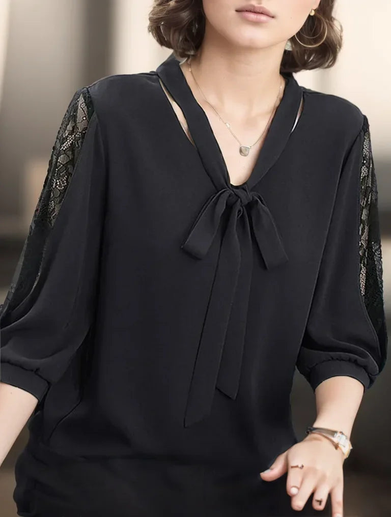 Black blouse with lace sleeves worn by a person, blurred background