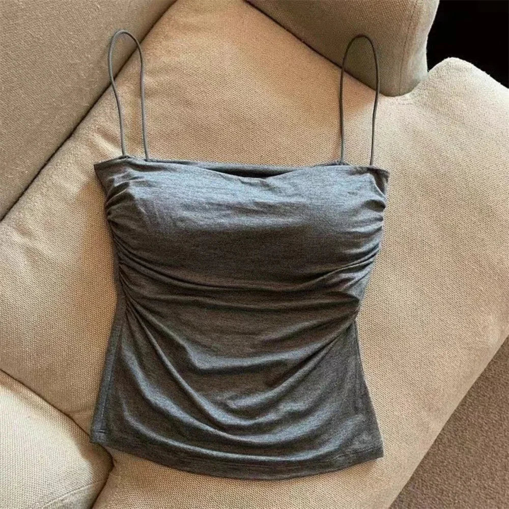 Gray strap top on a beige couch. Corset taille cintrée élégant, sans manches avec pliage, coussinet poitrine, bretelles fines, top court solide, mode UK FTF Market.