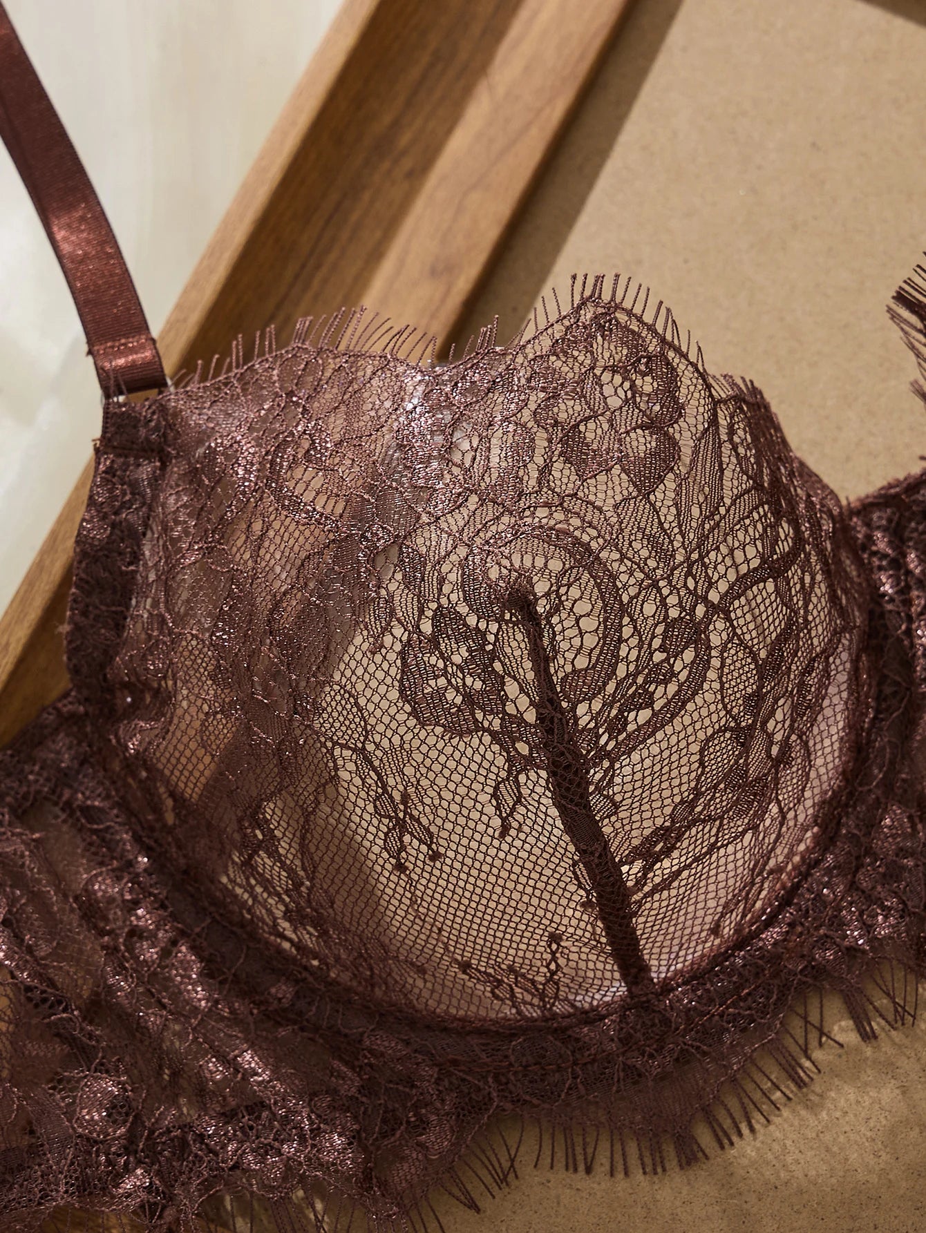 Brown lace bra on a wooden surface