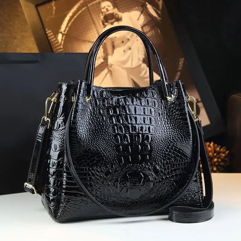 Black crocodile-patterned handbag on a white surface with a blurred background. Vintage genuine leather bucket tote bag with crocodile print. Soft medium-hardness leather, zipper closure, interior pockets. Stylish crossbody bag UK.