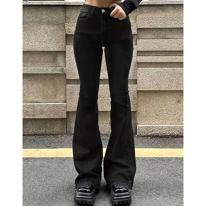 Person wearing black flared jeans standing against a textured wall. Women’s high waist flared jeans, stretchy bootcut denim trousers. Thin fabric, solid color, bell bottoms style for casual chic UK fashion.