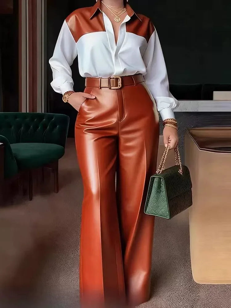 Person wearing a white shirt with brown accents and red pants, holding a green handbag indoors.
