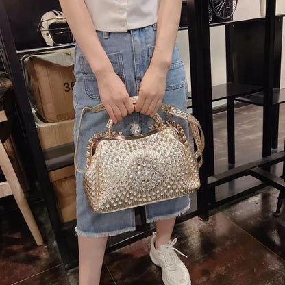 Person holding a decorative handbag in an indoor setting. Large genuine leather dumpling bag with diamond rhinestone clip and lock clasp. Soft handle, multiple compartments. Fashionable shoulder tote for women.