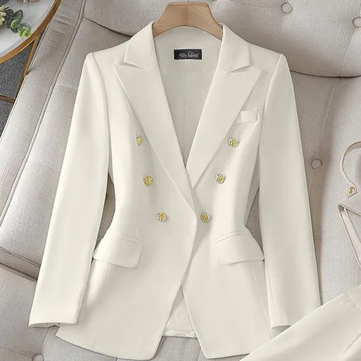 White blazer with gold buttons on a hanger against a neutral background