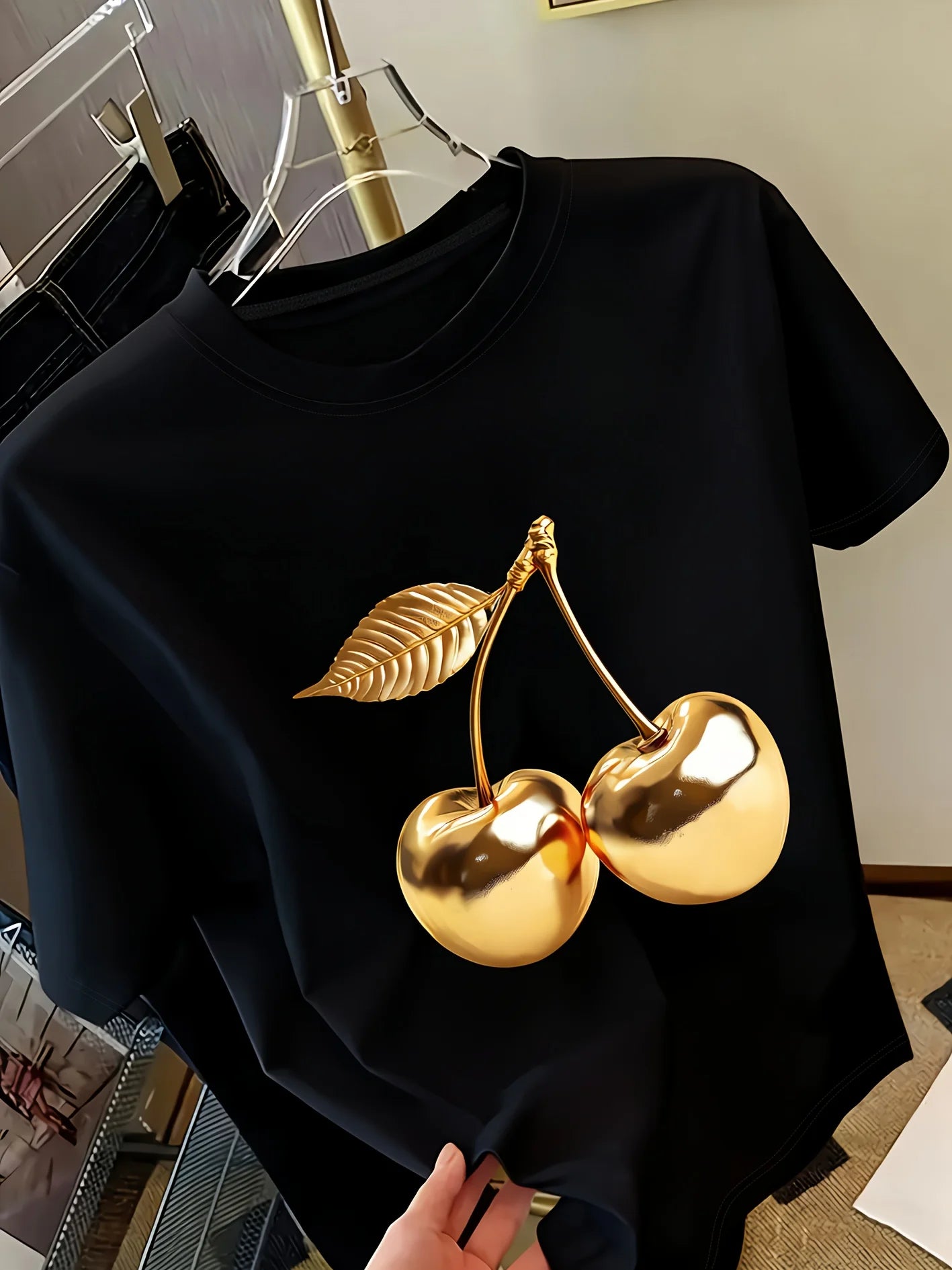 Women's white short sleeve t-shirt with gold metallic cherry print on hanger