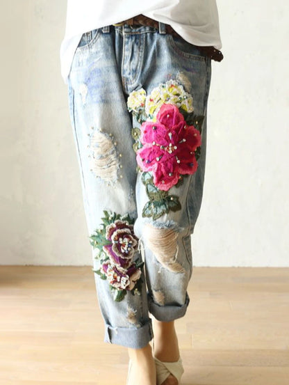 Denim pants with floral embroidery on a plain background. Floral embroidered harem jeans for women. Loose, high waist, elegant denim trousers. Vintage Y2K style. UK online store.