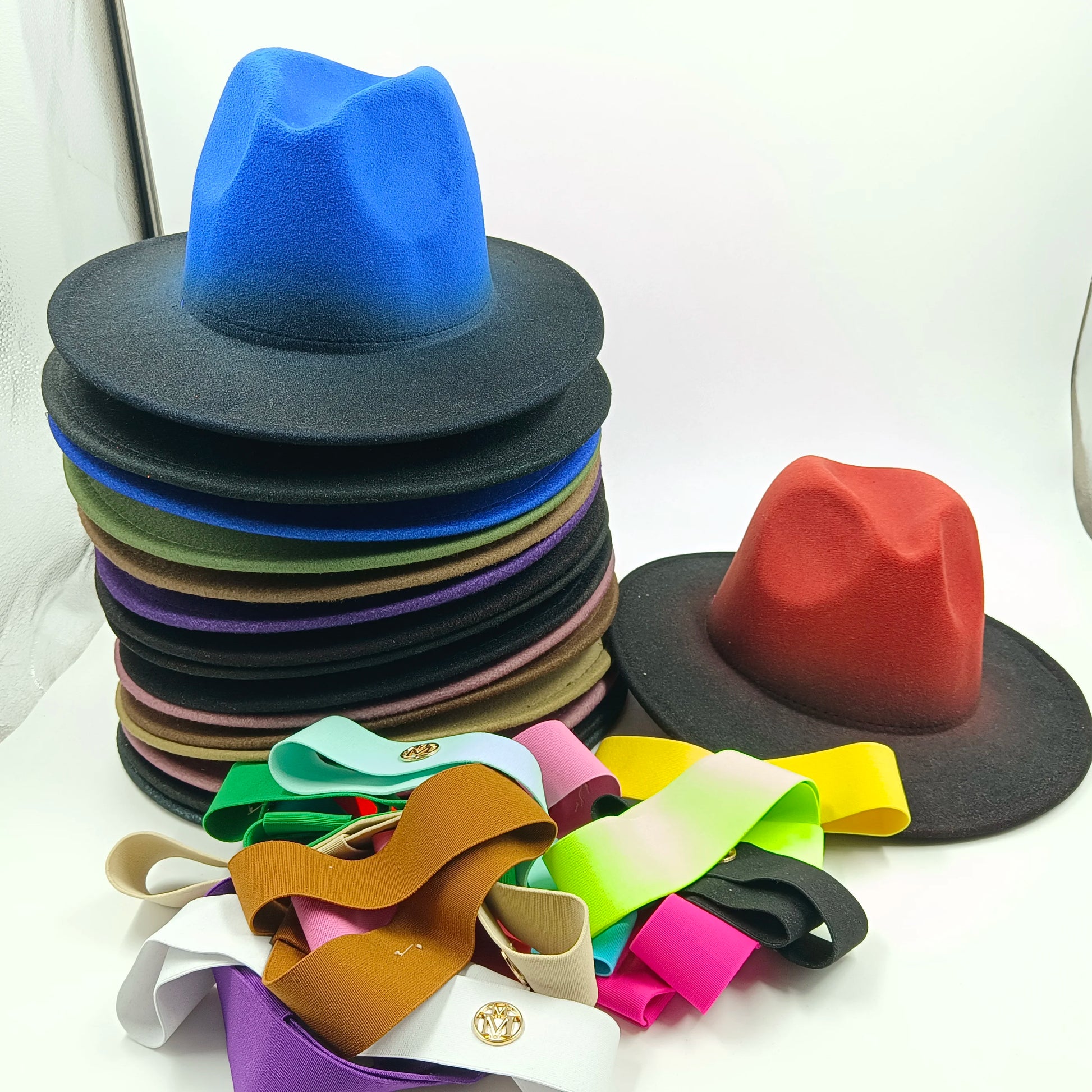 Stack of colorful hats with a variety of ribbon colors on a white background. Unisex double fedora hat, dual color gradient tie-dye, casual jazz style, cotton-polyester mix, suitable for outdoor autumn and spring.