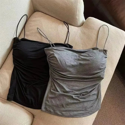 Black and gray strappy tops on a beige chair. Corset taille cintrée élégant, sans manches avec pliage, coussinet poitrine, bretelles fines, top court solide, mode UK FTF Market.
