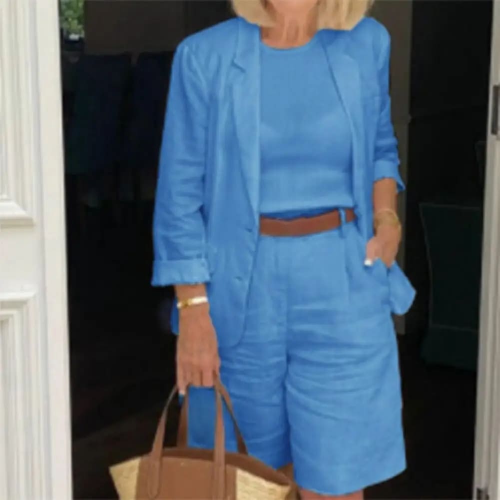 Image of a woman wearing a white Linen Look Blazer and Bermuda Shorts Co-ord Set with a brown belt and straw bag. Ideal smart casual summer outfit.