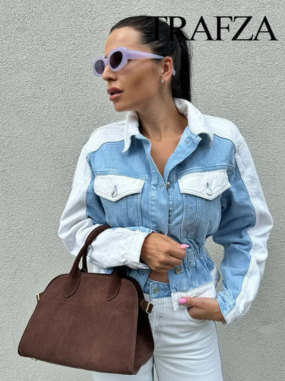 Woman wearing a denim jacket and sunglasses, holding a brown handbag against a gray background with 'Trafza' branding. Women’s 2-piece denim jacket and straight jeans set. Patchwork design, mid waist, turn-down collar, button closure, loose casual fit, streetwear.